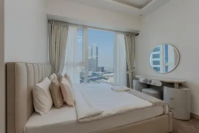 a bedroom with a bed with a large window at Cozy Studio in JLT I Medore in Dubai