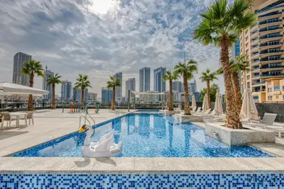 a swimming pool with palm trees and a resort at Charming 1BR Apartment in Sparkle Tower 1, Dubai Marina by Deluxe Holiday Homes in Dubai