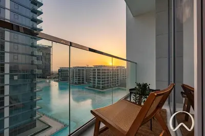a balcony with a table and a view of a city at Oraya - Sleek 1BR In District one , Direct Lagoon Access in Dubai
