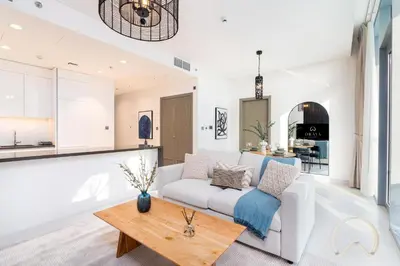a living room with a white couch and a table at Oraya - Sleek 1BR In District one , Direct Lagoon Access in Dubai