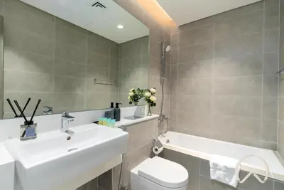 a bathroom with a sink and a toilet and a tub at Oraya - Sleek 1BR In District one , Direct Lagoon Access in Dubai