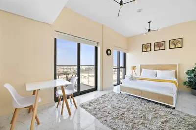 a bedroom with a bed and a desk and a table at Chic Urban Escape at Studio MAG 422 in Dubai