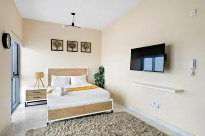 a bedroom with a bed and a flat screen tv at Chic Urban Escape at Studio MAG 422 in Dubai