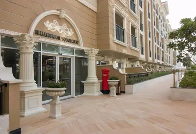 a large building with a red door on a street at Furnished Studio Ready to Move-in in Dubai