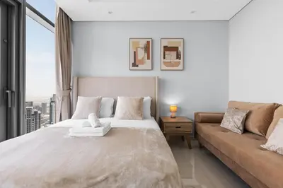 a bedroom with a large bed and a couch at Luxury Stay with Burj Khalifa Views & Infinity Pool in Dubai