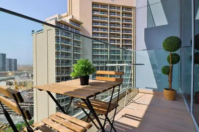 a balcony with a wooden table and chairs on a building at Bohemian Bliss 1 BR Apartment in Dubai