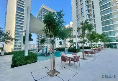 a courtyard with tables and chairs and buildings at Charming 1BR Apartment at Marina Vista Tower 2 Emaar Beachfront Dubai Marina by Deluxe Holiday Homes in Dubai