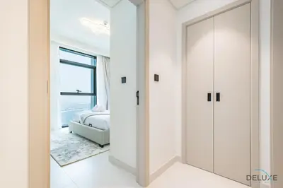 a bedroom with white walls and a sliding door at Charming 1BR Apartment at Marina Vista Tower 2 Emaar Beachfront Dubai Marina by Deluxe Holiday Homes in Dubai