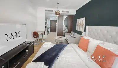 a bedroom with a bed and a living room at Rare Holiday Homes - Near Madame Tussauds - Goldcrest Executive - R3012 - Jumeirah Lake Towers in Dubai
