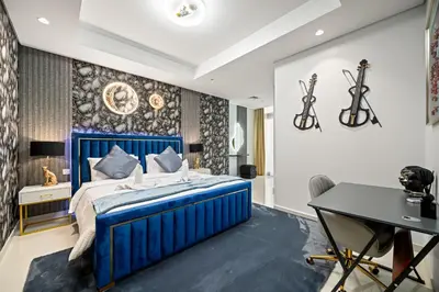 a bedroom with a blue bed and a desk at Amazing 2BR Apartment in Paramount Hotel Midtown, 64th-Floor Infinity Pool & Burj Khalifa Views in Dubai