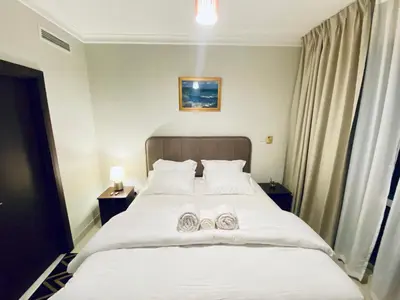 a bedroom with a bed with two towels on it at Greens in Dubai