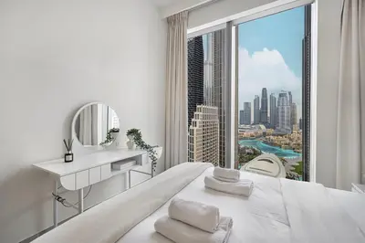a white bedroom with a view of a city at Lux 3BR With Spectacular Downtown Views in Dubai