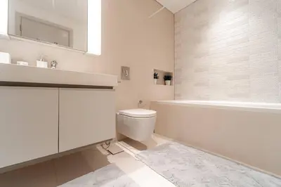 a white bathroom with a sink and a toilet at Luxury Sunrise Bay 1BR - Panoramic Sea View with Exclusive Amenities, by Think Realty in Dubai