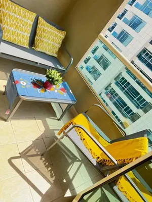 a living room with a yellow chair and a table at Great Location in Dubai Marina!! in Dubai