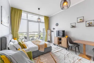 a bedroom with a bed and a desk and a tv at Elegant Studio in Damac Hills - Exclusive Living with Premium Amenities, Managed by Think Realty in Dubai