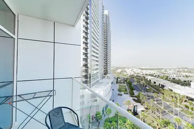 a balcony with a chair on a building at Elegant Studio in Damac Hills - Exclusive Living with Premium Amenities, Managed by Think Realty in Dubai