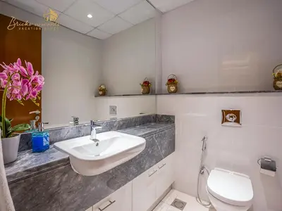a white bathroom with a sink and a toilet at Modern High Floor Canal View1 BHK in Dubai