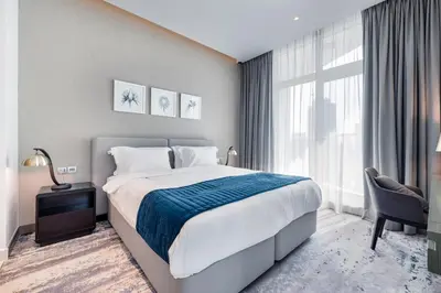 a bedroom with a bed and a large window at ALiving Chic Studio Apartment I Partial Burj Khalifa & Canal View I DAMAC Maison Prive B- 1417 in Dubai