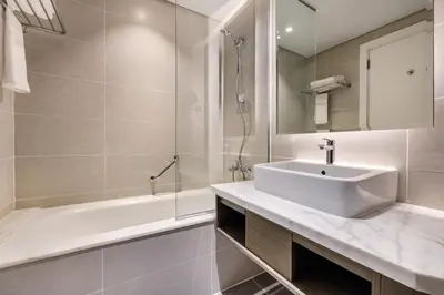 a bathroom with a sink and a shower and a tub at ALiving Chic Studio Apartment I Partial Burj Khalifa & Canal View I DAMAC Maison Prive B- 1417 in Dubai