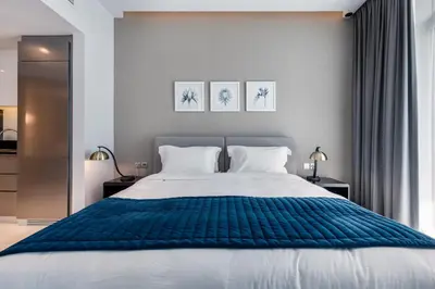 a bedroom with a large bed with a blue blanket at ALiving Chic Studio Apartment I Partial Burj Khalifa & Canal View I DAMAC Maison Prive B- 1417 in Dubai