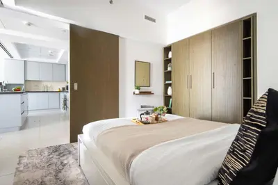 a bedroom with a large bed and a kitchen at Frank Porter - The Lofts Central Tower in Dubai