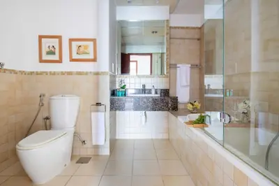 a bathroom with a toilet and a shower and a sink at Frank Porter - Sadaf 6 in Dubai