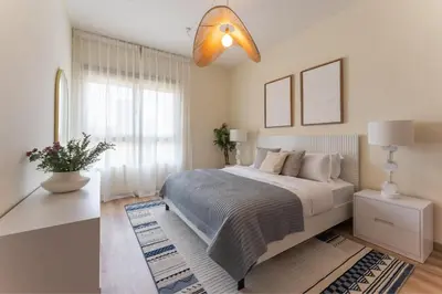 a white bedroom with a large bed and a window at HAVN - 1 Bedroom in The Greens, Barsha Heights in Dubai