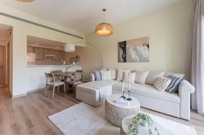 a living room with a white couch and a table at HAVN - 1 Bedroom in The Greens, Barsha Heights in Dubai