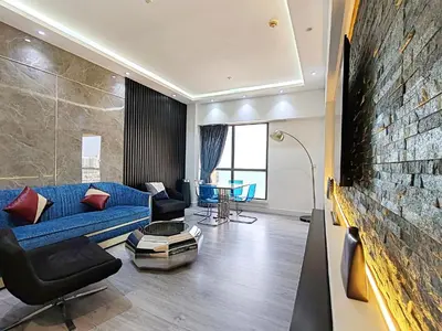 a living room with a blue couch and a brick wall at ELAN RIMAL MURJAN Suites in Dubai