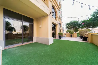 an office building with a green carpeted yard at ELAN RIMAL MURJAN Suites in Dubai