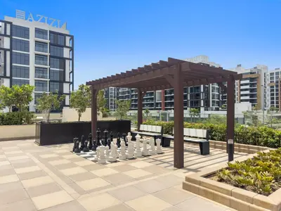 a chess set on a patio with a wooden canopy at Lovely Studio with Gym, Pool and BBQ Facilities in Dubai