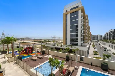 a view of the pool and playground in a building at Lovely Studio with Gym, Pool and BBQ Facilities in Dubai