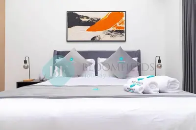 a bedroom with a bed with white sheets and pillows at Bloomfields 1br Azizi Gardens Meydan in Dubai