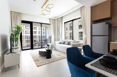 a living room with a white couch and blue chairs at Elegant 1 Bedroom at Creek Beach Bayshore in Dubai