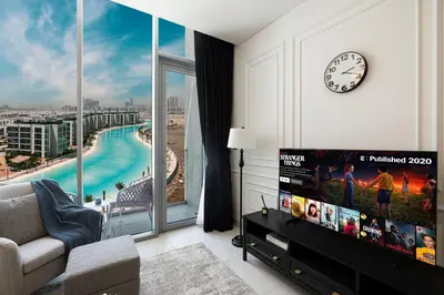 a living room with a tv and a large window at Crystal Lagoon View Beach access Fast Wi-Fi in Dubai