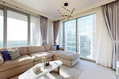 a living room with a couch and large windows at Forte Tower 2 - Warm Two Bedroom in Dubai