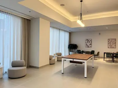 a living room with a table and chairs at Forte Tower 2 - Warm Two Bedroom in Dubai