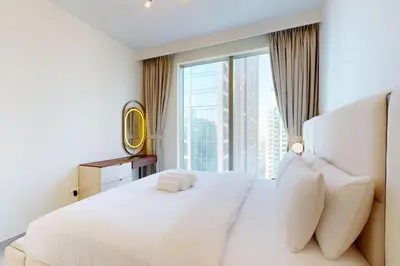 a bedroom with a large white bed with a large window at Forte Tower 2 - Warm Two Bedroom in Dubai