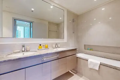 a bathroom with two sinks and a tub and a mirror at Forte Tower 2 - Warm Two Bedroom in Dubai