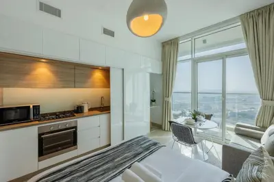 a kitchen and living room with a view of the ocean at Studio One - Gorgeous Studio in Dubai