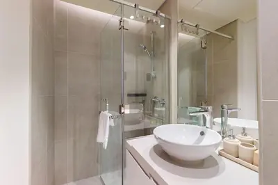 a bathroom with a white sink and a shower at Studio One - Gorgeous Studio in Dubai