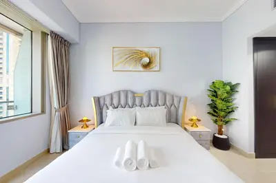 a bedroom with a bed with white shoes on it at Ocean Heights - Exquisite One Bedroom in Dubai
