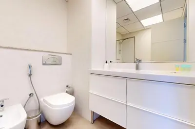 a bathroom with a sink and a toilet and a mirror at Bay Central - Enticing Two Bedroom in Dubai