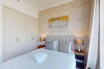 a bedroom with a large white bed and two lamps at Bay Central - Enticing Two Bedroom in Dubai