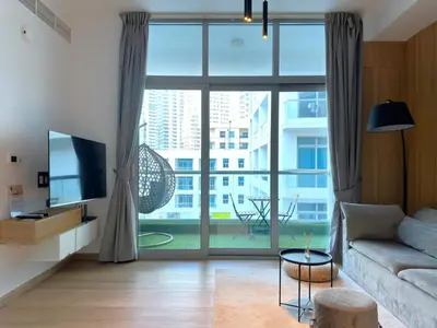 a living room with a couch and a large window at Ultra Luxury Flat Fully Upgrade with Balcony in Marina in Dubai