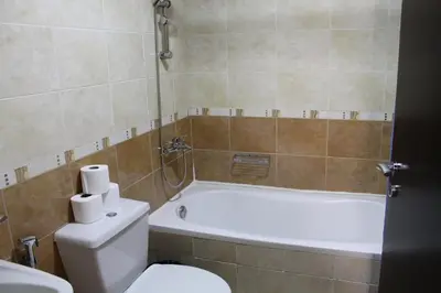 a bathroom with a tub and a toilet and a sink at Newly furnished 1 Bedroom, high floor, amazing view, close to metro in Dubai