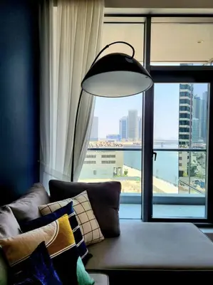 a living room with a couch and a large window at Alaia Retreat in Dubai