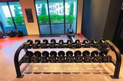 a gym with a bench filled with lots of dumbbells at Full Seaview Comfortable Apt La Mer Dubai in Dubai