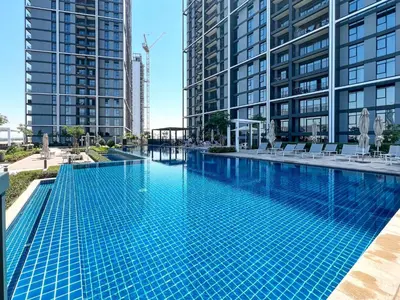 a swimming pool in the middle of two tall buildings at Elegant 1 bedroom in Creek Edge in Dubai