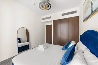 a bedroom with a large bed and a mirror at Elegant 1 bedroom in Creek Edge in Dubai